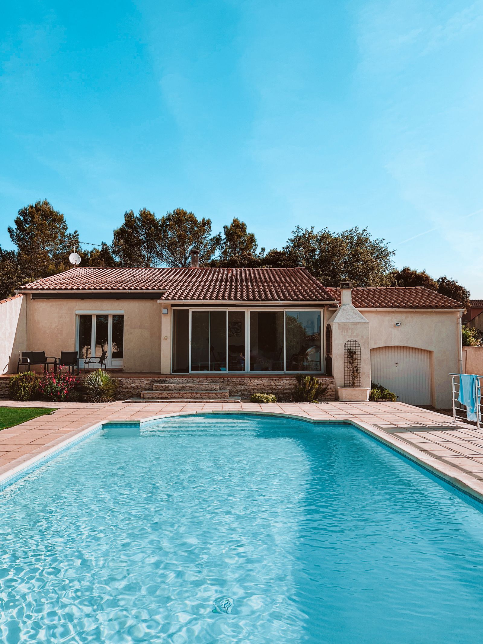 Fotografía ilustrativa de una piscina junto a una vivienda